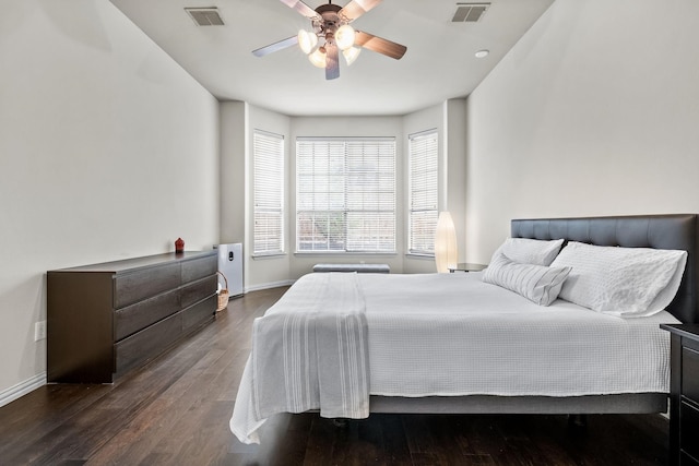 bedroom with visible vents, baseboards, and wood finished floors