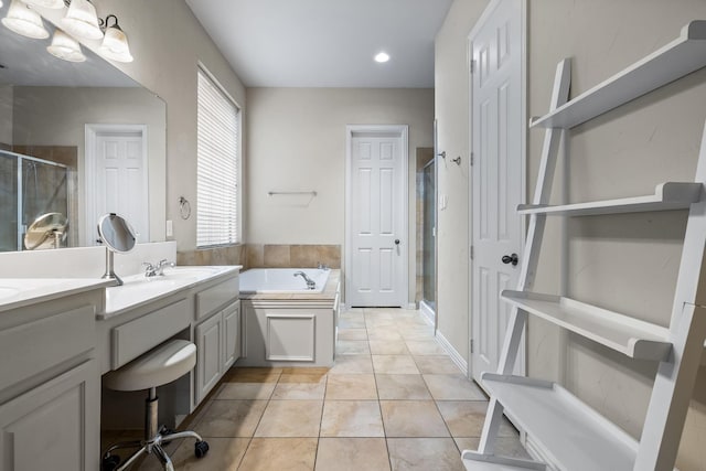 bathroom with a garden tub, double vanity, a stall shower, a sink, and tile patterned floors