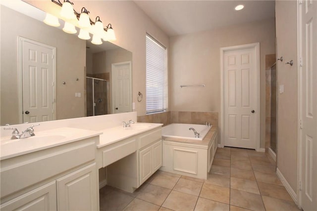 full bathroom with a stall shower, tile patterned flooring, a garden tub, and a sink