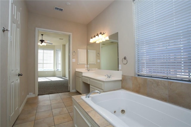 bathroom with double vanity, visible vents, a tub with jets, and tile patterned floors