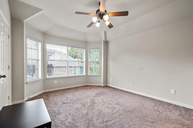 empty room with lofted ceiling, a ceiling fan, baseboards, and carpet flooring