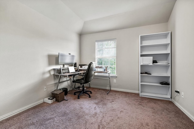 carpeted office space with vaulted ceiling and baseboards