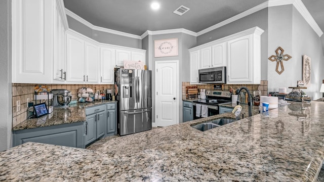 kitchen featuring visible vents, white cabinets, dark stone countertops, stainless steel appliances, and crown molding