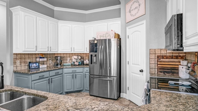 kitchen with crown molding, stainless steel appliances, decorative backsplash, stone countertops, and white cabinets