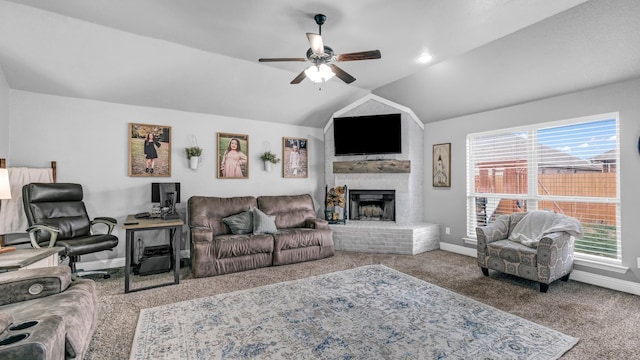 carpeted living area featuring a ceiling fan, a brick fireplace, vaulted ceiling, and baseboards