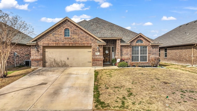 traditional-style house with a garage, concrete driveway, brick siding, and roof with shingles