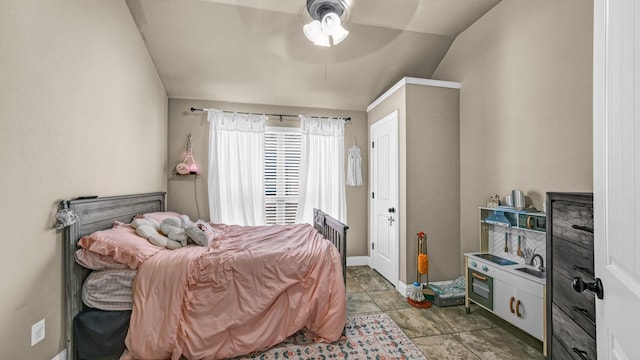 bedroom with vaulted ceiling, a ceiling fan, and baseboards