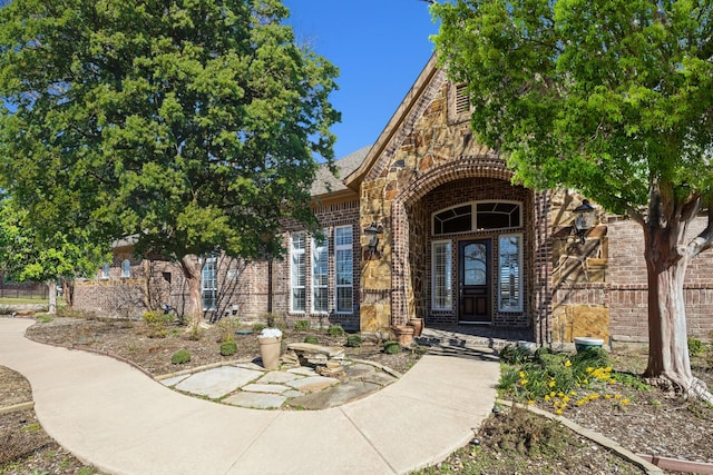 property entrance with stone siding and brick siding