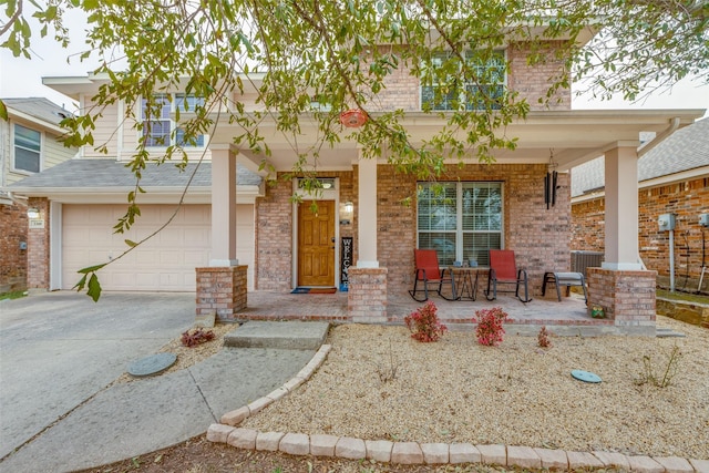 view of front facade featuring covered porch, concrete driveway, brick siding, and a garage