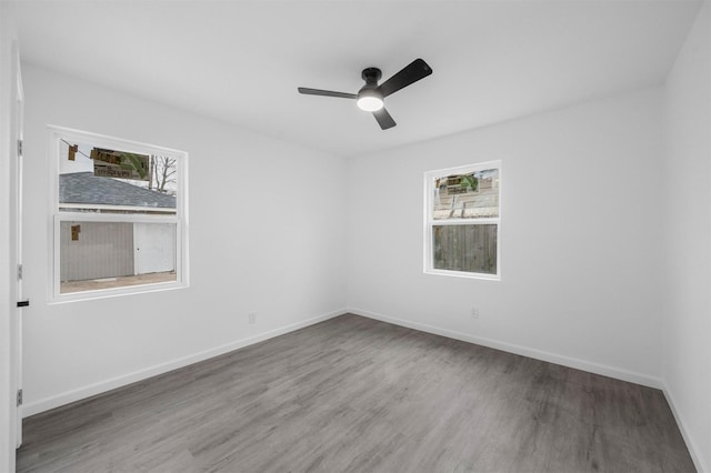 unfurnished room with ceiling fan, wood finished floors, and baseboards