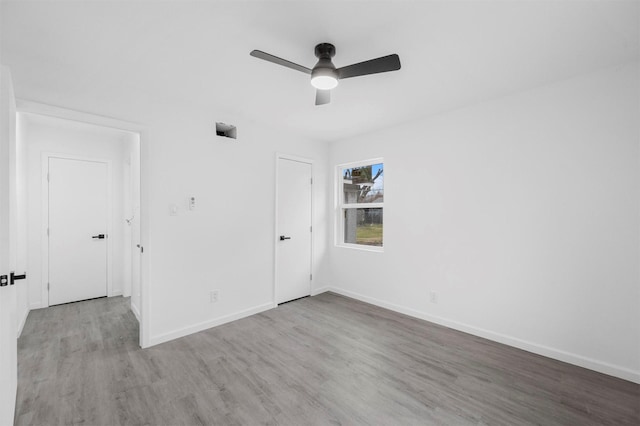 unfurnished bedroom with a ceiling fan, baseboards, and wood finished floors