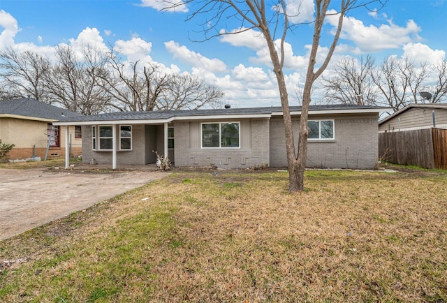 ranch-style home with brick siding, fence, and a front lawn