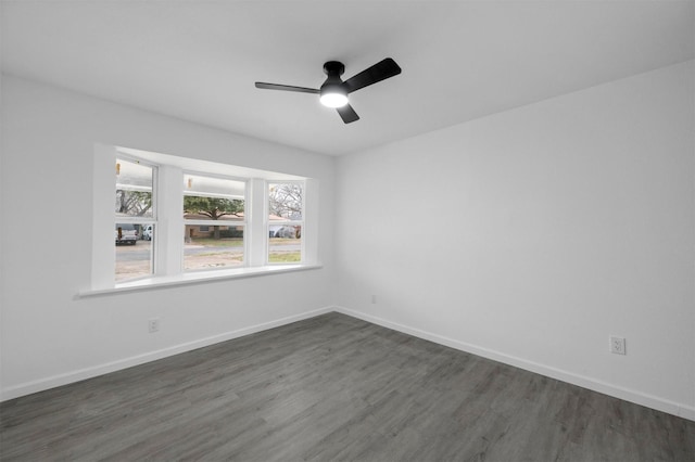 empty room with dark wood-style floors, ceiling fan, and baseboards