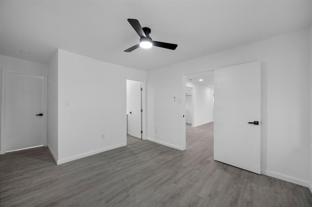 unfurnished bedroom with ceiling fan, baseboards, and wood finished floors