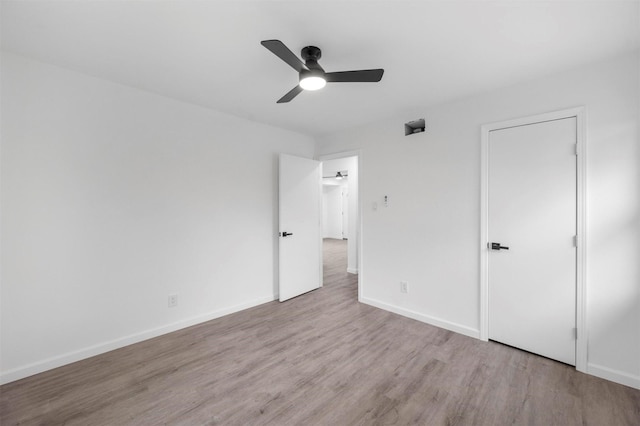 unfurnished bedroom featuring wood finished floors, a ceiling fan, and baseboards