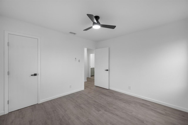 unfurnished bedroom with visible vents, baseboards, ceiling fan, and wood finished floors