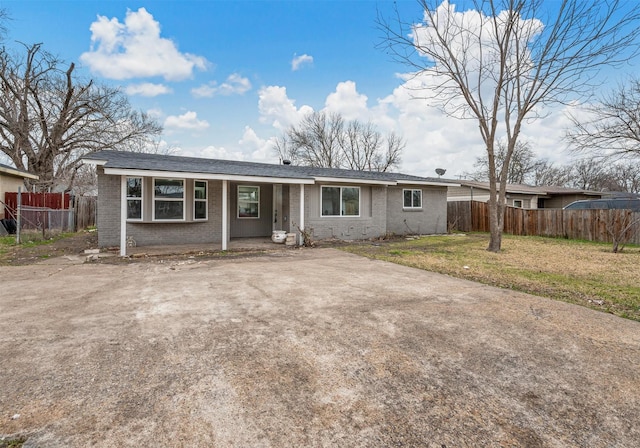 single story home featuring a front yard, fence, and brick siding