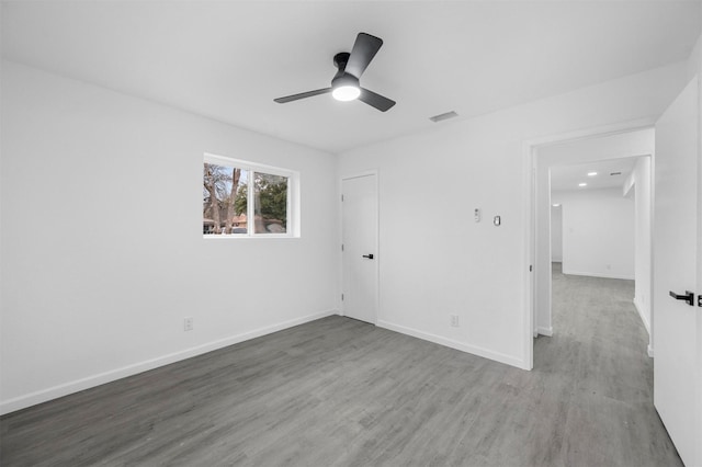 unfurnished bedroom featuring wood finished floors, visible vents, and baseboards