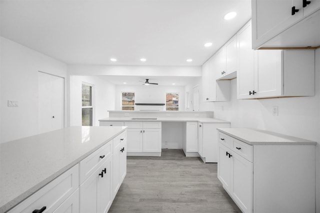 kitchen featuring ceiling fan, recessed lighting, a peninsula, white cabinets, and light wood-type flooring