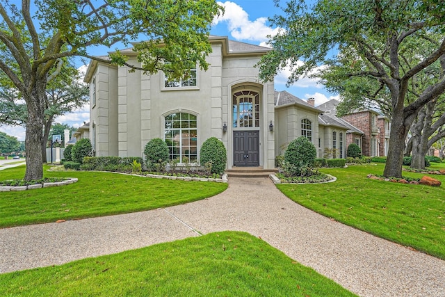 mediterranean / spanish house with a front lawn and stucco siding