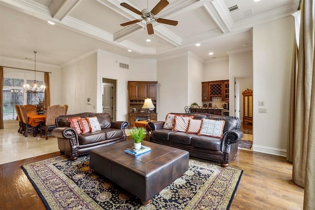 living area featuring a high ceiling, coffered ceiling, wood finished floors, visible vents, and beam ceiling