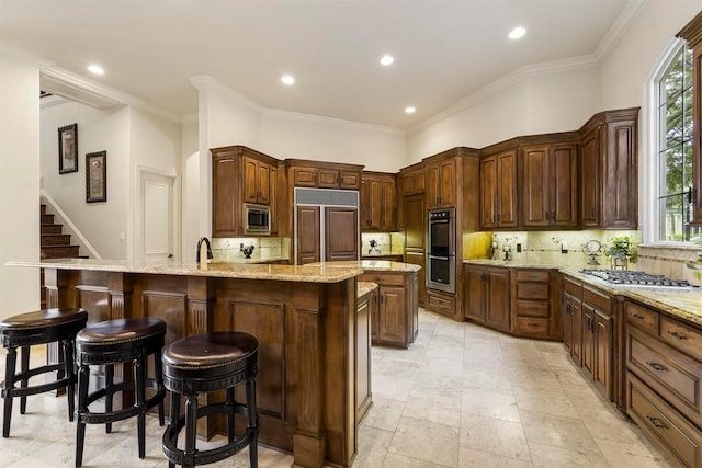 kitchen featuring light stone countertops, a breakfast bar, backsplash, and built in appliances