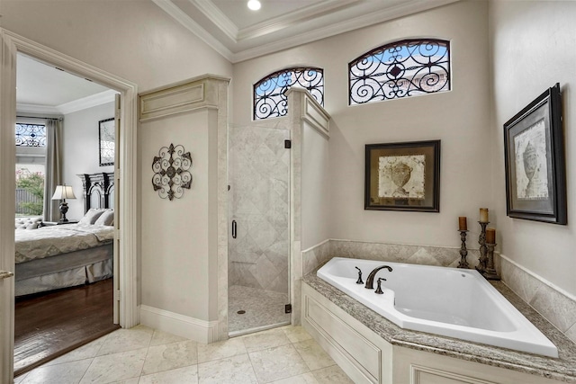 bathroom with a stall shower, baseboards, ensuite bathroom, crown molding, and a bath