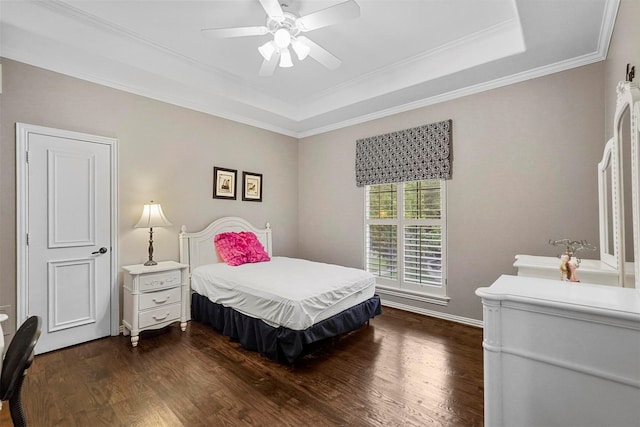 bedroom featuring crown molding, a raised ceiling, dark wood finished floors, and a ceiling fan