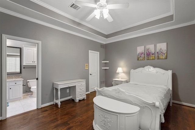 bedroom featuring ensuite bath, wood finished floors, visible vents, and baseboards