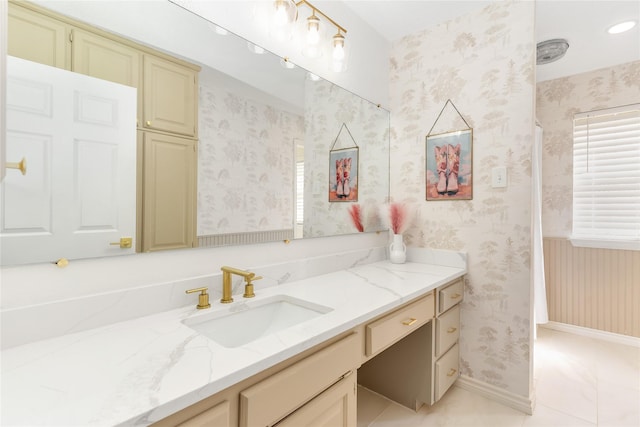 bathroom with wallpapered walls, tile patterned flooring, baseboards, and vanity