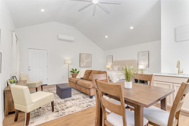 dining space with baseboards, a wall unit AC, ceiling fan, light wood-style flooring, and vaulted ceiling