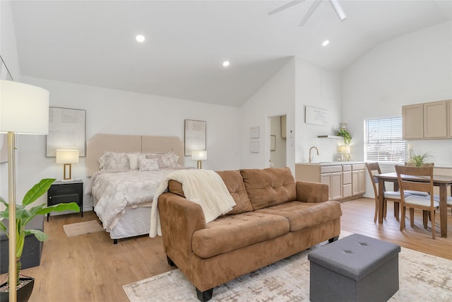 bedroom featuring light wood-style floors, high vaulted ceiling, a sink, and recessed lighting