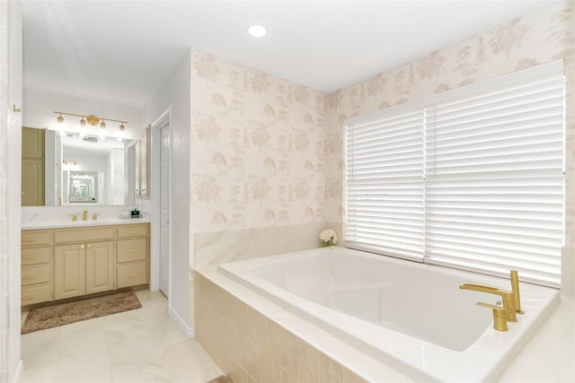 full bath featuring a garden tub, vanity, and wallpapered walls