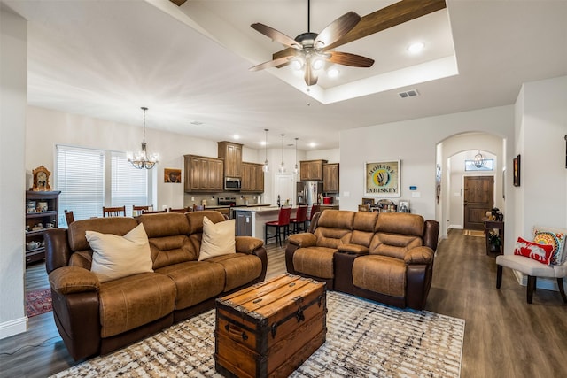 living area with arched walkways, recessed lighting, ceiling fan with notable chandelier, dark wood-type flooring, and visible vents