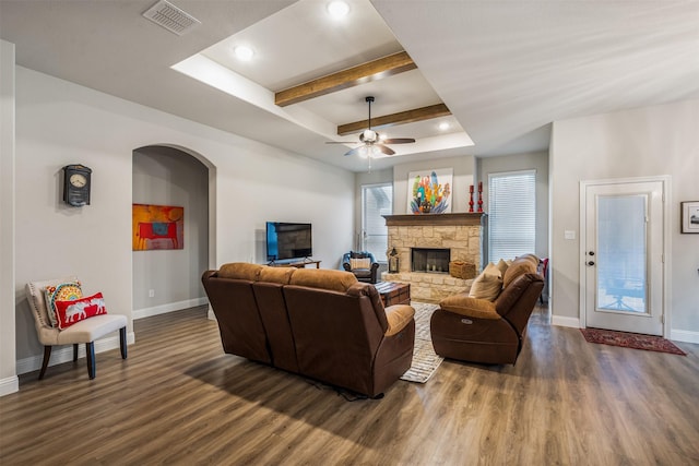 living room with dark wood-style flooring, a raised ceiling, visible vents, and baseboards