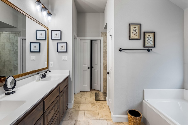 full bath featuring a garden tub, a sink, baseboards, and double vanity