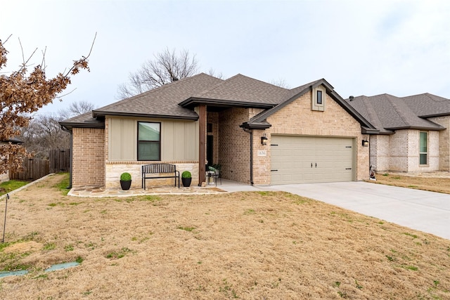 view of front facade featuring an attached garage, a shingled roof, brick siding, fence, and driveway