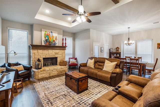 living room with recessed lighting, dark wood-style flooring, a tray ceiling, a fireplace, and ceiling fan with notable chandelier