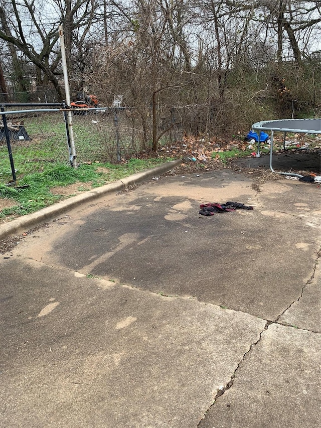 view of yard with a trampoline and fence