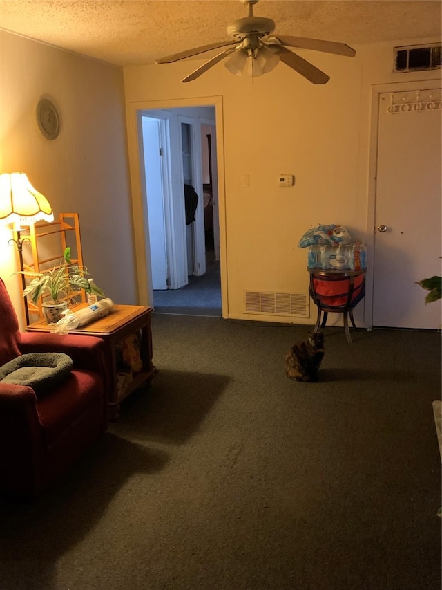 carpeted living area with ceiling fan, visible vents, and a textured ceiling