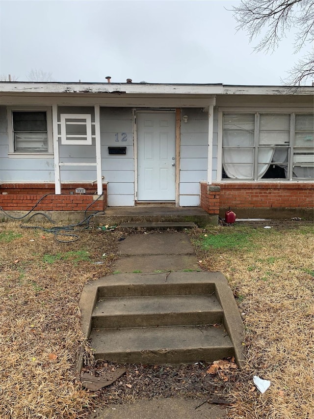 doorway to property with brick siding