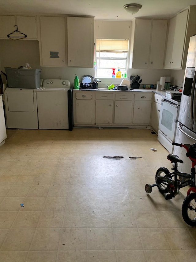 kitchen with light floors, light countertops, white electric range, and washing machine and clothes dryer