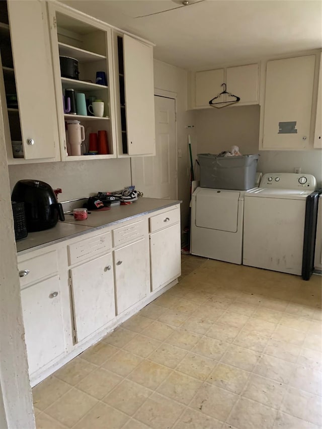 laundry room with cabinet space, washing machine and dryer, and light floors