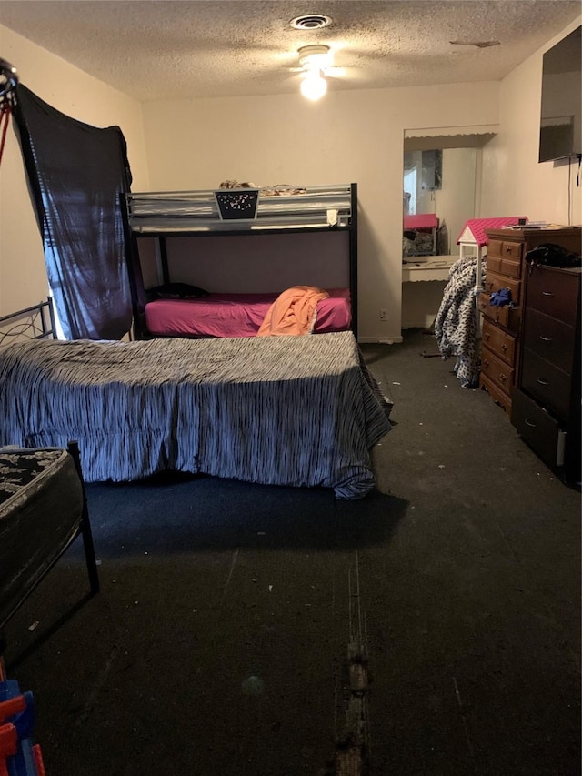 carpeted bedroom with a textured ceiling and visible vents