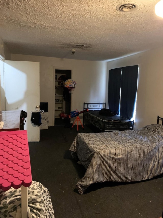 bedroom with a textured ceiling and visible vents