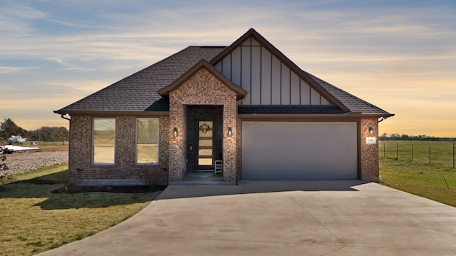 view of front of home with a garage, a shingled roof, fence, driveway, and board and batten siding