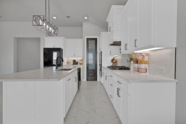 kitchen with gas cooktop, a sink, marble finish floor, black fridge, and custom range hood