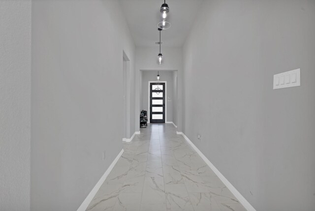 hallway with marble finish floor and baseboards