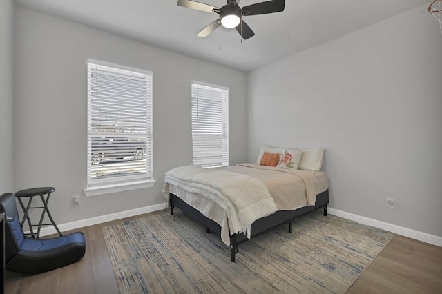 bedroom featuring wood finished floors, a ceiling fan, and baseboards