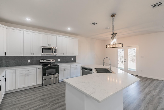 kitchen with tasteful backsplash, visible vents, appliances with stainless steel finishes, white cabinetry, and a sink